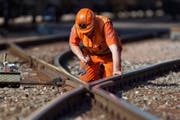 Ein Bauarbeiter macht an einem Gleis Reparaturen. (Bild: Keystone / Martin Ruetschi)