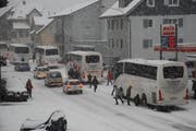 Stau vergangenes Wochenende in Wolfenschiessen: Die Cars werden mit Schneeketten wintertauglich gemacht. (Bild: Franz Hess / Neue NZ)