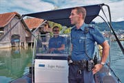Die Polizisten Pfister (vorn) und Wettach lassen ihren Blick über das Geschehen im Zuger Hafen schweifen. (Bild: Raphael Biermayr (16. Juli 2017))