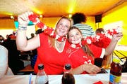 Mit Hawaii-Ketten und Nati-Tenü am Fanen: Marika und Anna-Maria Albrecht (links im Bild). Rechts: Nach dem 1:0 der Rumänen zog sich so mancher Fan kurz zurück. (Bilder Stefan Kaiser)