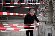 Shahram Entebhabi (48) deckt den Luzerner Rathaussteg mit rotweissem Absperrband ein. (Bild: FelderVogel)