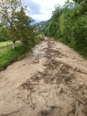 Bei der «gedeckten Brücke» in Giswil fliesst eine Masse aus Wasser, Schlamm, Holz und Steinen die Laui hinunter. (Bild: Leserbild)