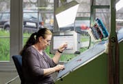 Eine Mitarbeiterin der Lantal Textiles AG prüft einen produzierten Teppich auf Fehler. (Bild: Peter Klaunzer/Keystone (Melchnau, 12. April 2012))
