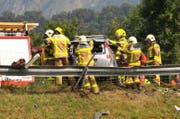 Rettungskräfte bemühen um die Insassen eines am Unfall beteiligten Fahrzeuges. (Bild: Robert Hess / Neue OZ)