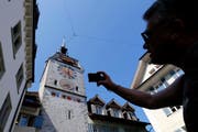 Ein Tourist auf Besuch in der Stadt Zug schiesst ein Foto vom Zuger Zytturm. (Bild: Stefan Kaiser/Neue ZZ)