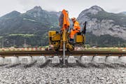 Ein Arbeiter verlegt auf der Neat-Strecke bei Erstfeld Schienen. Bild: Gaëtan Bally/Keystone (20. August 2014)