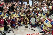 Die Spieler von Servette-Genf feieren den Sieg im Spengler Cup Final. (Bild: Keystone / Peter Schneider)