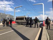 Die Polizei steht parat: Mit Gewehr und Schlagstock bewaffnet. (Bild: kük)