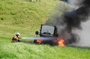 Die Feuerwehr beim Löschen der brennenden Heuballenpresse. (Bild: Kapo Schwyz)