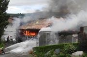 Die Feuerwehr verhindert, dass das Feuer auf weitere Gebäude übergreift. (Bild: Kantonspolizei Schwyz)