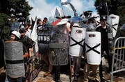Rechtsextreme verbarrikadieren sich hinter Schutzschildern mit ihrem Symbol: schwarzes Kreuz auf weissem Grund. (Bild: Joshua Roberts/Reuters (Charlottesville, 12. August 2017))