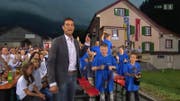 Moderator Roman Kilchsberger verkündet das Resultat: Oberägeri siegt (rechts), Cham spendet Applaus. (Bild: SRF)