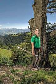 Revierförster Hans Ming (58) steht mit seiner Messkluppe vor einer Buche im Gebiet Oberänzi. Im Hintergrund die Pilatuskette. (Bild Nadia Schärli)