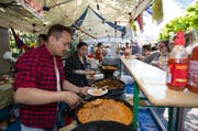 Norbv und Chime Karma bereiten tibetische Spezialitäten für die Besucher zu. (Bild: Roger Zbinden / Neue ZZ)