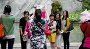 Chinesische Touristinnen machen ein Gruppenfoto vor dem Löwendenkmal in Luzern. (Bild Corinne Glanzmann)