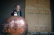 Franziska von Blarer wirft einen Zettel in die Kupferkugel beim Pavillon «Niklaus von Flüe – Unterwegs», der auf eine Tour durch die ganze Schweiz startet. (Bild: Corinne Glanzmann (Flüeli-Ranft, 27. Juni 2017))