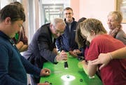 Robert Küng demonstriert, wie die Solarautos mit Licht aus der Taschenlampe angetrieben werden können. Im Hintergrund steht Felix Graf. (Bild: pd/ckw)