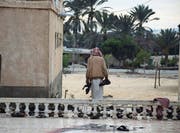 Ein Mann sammelt Schuhe von Opfern des Anschlags in Bir al-Abed. (Bild: Ahmed Hassan (25. November 2017))