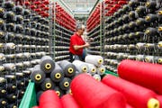 Ein Mitarbeiter der Lantal Textil AG in Melchnau bestückt eine Webmaschine. (Bild: Keystone)