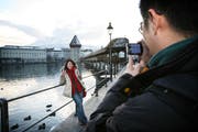 Ein taiwanesisches Paar macht Erinnerungsfotos bei der Luzerner Kapellbrücke. (Bild Manuela Jans/Neue LZ)