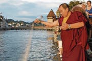 Lama Tsewang Nyima übergibt das Mandala der Reuss. Zahlreiche Besucher hatten zuvor die Entstehung des tibetischen Kunstwerkes verfolgt. (Bild: Keystone)