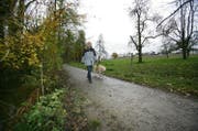 Eine Frau läuft mit ihrem Hund in Oberkirch der Sure entlang. (Bild Philipp Schmidli)