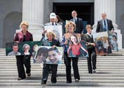 Demokratische Senatoren demonstrierten gestern gegen Trumpcare. Auf den Fotos sollen US-Bürger abgebildet sein, die nach eigenen Aussagen durch die Gesundheitsreform ihre Krankenversicherung verlieren würden. (Bild: Jim Scalzo/EPA (Washington, 27. Juni 2017))
