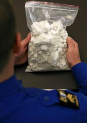 Ein Beamter der Luzerner Polizei hält einen Sack mit einem Kilo Kokain. (Bild: Archiv LZ)