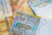 Zehnernoten mit dem Aufkleber "I love Grundeinkommen, Ja-Oui-Si.ch, 5. Juni 2016", fotografiert an der Aktion "Für ein Bedingungsloses Grundeinkommen" im März in Zürich. (Bild: Keystone / Ennio Leanza)