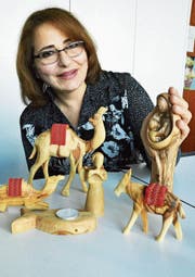 Die christliche Palästinenserin Faten Mukarker mit Krippenfiguren aus Olivenholz, die von Handwerkerfamilien aus Bethlehem mit viel Liebe hergestellt worden sind.