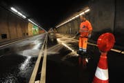 Nachdem die Tunnelwand in der Nische abgespritzt worden ist, wird die Strasse gereinigt. (Bild: Urs Hanhart / Neue UZ)
