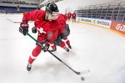 Von einem Teamkollegen bedrängt, kontrolliert Nino Niederreiter den Puck in der gestrigen Übungseinheit der Schweizer in der Trainingshalle des Eispalastes von Moskau. (Bild: Keystone/Salvatore Di Nolfi)