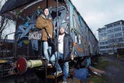 Sie bauen den alten Eisenbahnwagen vor der Industrie 45 in ein besonderes Café um: Fabio Fölmli (links) und Kai Imholz. Die Dritte im Bunde ist Laura Hürlimann. Sie fehlt auf dem Bild. (Bild: Werner Schelbert (Zug, 4. Januar 2018))