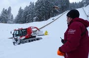 Schanzenmitarbeiter Toni Töngi schaut, wie Pistenfahrzeugfahrer Noldi Hess mit der brandneuen Windenmaschine die Landebahn präpariert. (Bild: PD)