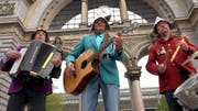 Die drei Musiker der «Musig 6020» vor dem Luzerner Torbogen auf dem Bahnhofplatz: Robert Brun (Akkordeon), Werner Richli (Gitarre und Songwriter) und Roland Huber (Schlagzeug und Gesang). (Bild: Screenshot Youtube)