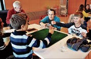 Die Schüler Leo und Eliáš (im Vordergrund, von links) klatschen einander ab, die Jasslehrerin Klara Betschart (Mitte) hält sie zum Vorwärtsmachen an. Der Beisitzer Werner Huber und die Schülerin Alexandra beobachten die Szene. (Bild: Raphael Biermayr (14. November 2017))