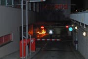 Ein Polizeibeamter steht vor dem Brand in der Tiefgarage. (Bild: Luzerner Polizei)