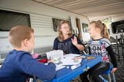 Sandra Gerzner beim Schulunterricht mit ihren Kindern Samuel und Amélie vor ihrem Wohnwagen. (Bild Pius Amrein)