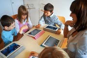 Lukas, Ladina und Christian (von links) entdecken zusammen mit Karin Mathis die Geheimnisse des iPad. (Bild: Romano Cuonz / Neue NZ)