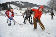 Patrick Kälin, Robin Boutellier und Corsin Fässler (von links) spielen Eishockey auf dem gefrorenen Sihlsee. (Bild Boris Bürgisser/Neue LZ)