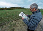 Robert Stierli schaut sich an, wo künftig ein Kiesweg über das Feld führen soll. (Bild: Stefan Kaiser (Cham, 8. November 2017))