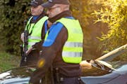 Zwei Grenzwächter kontrollieren auf einer Strasse bei Chiasso Fahrzeuge. (Bild: Keystone/Gaetan Bally)