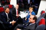 Italiens Premierminister Matteo Renzi, Bundespräsident Johann Schneider-Ammann, die deutsche Bundeskanzlerin Angela Merkel und Frankreichs Staatschef François Hollande im Eröffnungszug unterwegs von Erstfeld nach Bodio. (Bild: Keystone / Gabriele Putzu)
