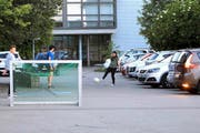 Gleich wird ein Auto den Schulhausplatz verlassen, derweil die Kids weiter Fussball spielen. (Bild Charly Keiser)