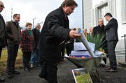 IG-Präsident Albert Frank (Mitte) mit dem Schubkarren voller Unterschriften und einem Plan mit den Vorstellungen der IG, wie das Delta gestaltet werden könnte. Im Hintergrund Baudirektor Hans Wicki (rechts). (Bild: Geri Wyss / Neue NZ)