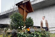 Hildegard Bütler beim Andachtsort unterhalb der neuen Tobelbrücke. Das Kreuz wurde fast durch- gesägt (kleines Bild), die Christusfigur hat Bütler entfernen lassen. (Bilder Werner Schelbert)
