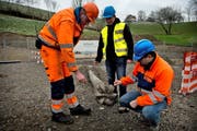 Michael Sauder (v. l.), Cardin Pinggera und Claudio Canassi neben der Bohrmaschine, die am 16. Februar am Sonnenberg den Durchstich für die neue Quellwasserleitung geschafft hat. (Bild: Nadia Schärli / Neue LZ)