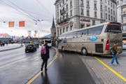 Links: Der Schwanenplatz gestern zur Mittagszeit: An diesem Ort werden Fussgänger häufig durch zu- und wegfahrende Reisecars behindert. (Bild: Roger Gruetter)