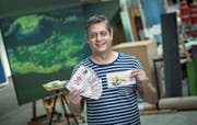 Der Künstler Nils Nova in seinem Atelier in Emmen. In der Hand hält er seine als Kind gezeichneten Schweizer Banknoten. (Bild: Pius Amrein (Emmen, 13. Juli 2017))