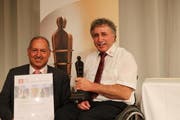 Die Geschäftsleitungsmitglieder der Schweizer Paraplegiker-Vereinigung Urs Styger (links) und Erwin Zemp nehmen posieren mit der Auszeichnung. (Bild: pd / Schweizer Paraplegiker-Vereinigung SPV)